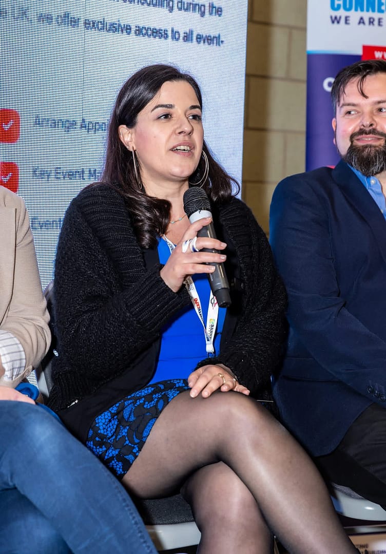 Stefania Arca speaking on a panel discussion at the B2B Expo Portsmouth, holding a microphone